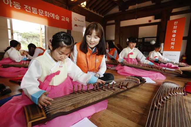 서울 남산국악당 체험실에서 21일 열린 ‘한화예술더하기’ 사회공헌 활동. 한화그룹 임직원 봉사자가 아이들의 가야금 교육을 돕고 있다.  [사진제공=한화그룹]