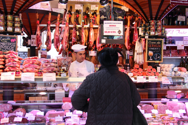 A customer eyes the selection of jamon at the Mercado de la Paz near the Plaza de Colón in Madrid, Spain. (Julie Jackson/The Korea Herald)
