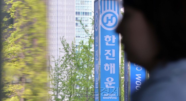 국내 양대 해운사 중 한 곳인 한진해운이 이사회를 열어 재무구조 개선과 경영 정상화를 위해 25일 자율협약을 신청하기로 밝힌 가운데 25일 오전 서울 여의도 한진해운 본사 내 보유 선박의 모형 앞을 이 회사 직원이 지나가고 있다. 이상섭 기자/babtong@heraldcorp.com
