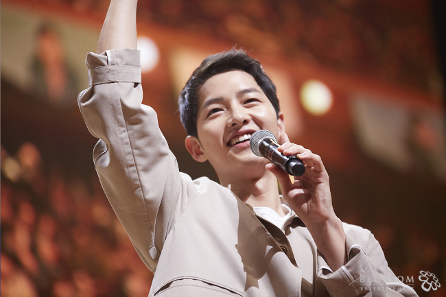 Song Joong-ki waves to the audience at a fan meeting in Seoul on April 18. (Blossom Entertainment)