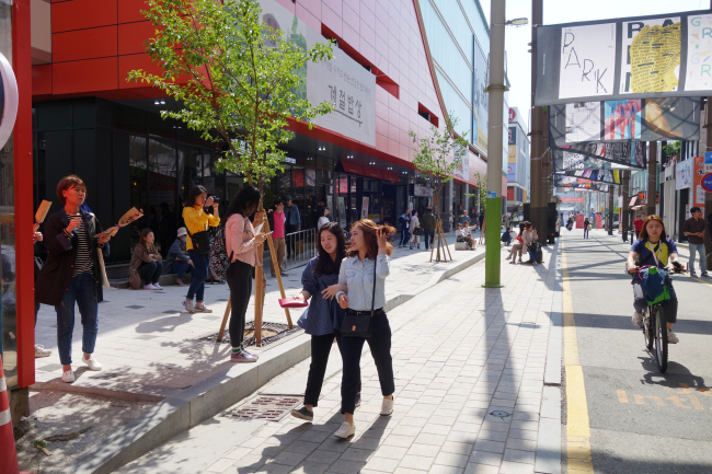 Festivalgoers stand outside the CGV Theater on Jeonju’s Cinema Street on Friday. (Rumy Doo/The Korea Herald)