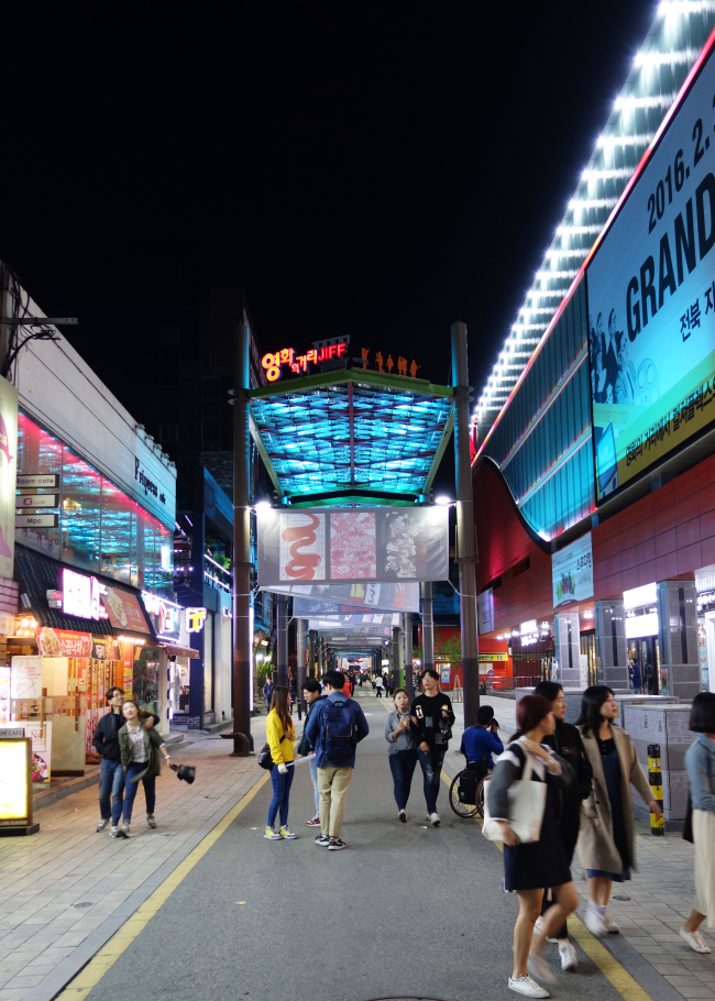 Nighttime filmgoers flock to the entrance of Jeonju’s Cinema Street on Friday night. (Rumy Doo/The Korea Herald)
