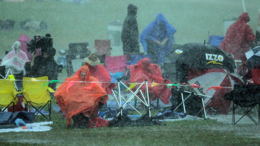 People listen to Davell Crawford in the rain at the Gentilly Sage during the second Sunday of the New Orleans Jazz Fest at the Fair Grounds on May 1. (AP-Yonhap)