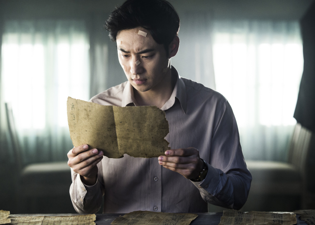 Hong Gil-dong, played by Lee Je-hoon, discovers a document in “Phantom Detective.” (CJ E&M)