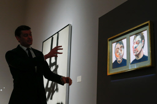 A man talks about the artwork “Two Studies for Self-Portrait” painted by artist Francis Bacon, during a press preview on April 29. (AFP-Yonhap)