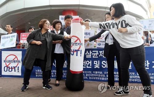 9일 오전 롯데마트 울산점 앞에서 울산환경운동연합, 울산시민연대 등 시민사회단체 회원들이 '옥시 아웃'이 적힌 풍선을 주먹으로 치는 퍼포먼스를 하고 있다. (Yonhap)