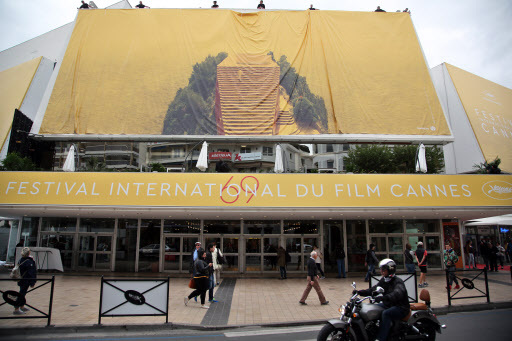 Workers place the official banner on the Palais de Festival during preparations for the 68th international film festival in Cannes, southern France, on Monday. (AP-Yonhap)