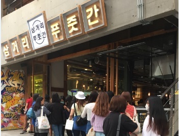Customers wait in line to eat at YG Entertainment’s Hongdae barbecue restaurant Samgeori Pujutgan. (YG Entertainment)