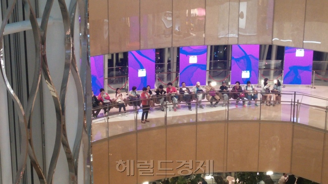 쇼핑에 지친 중국인들이 7층에 위치한 의자에서 쉬고 있다.