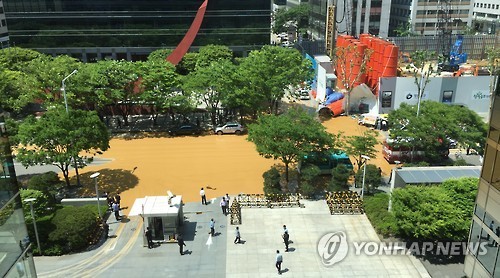 12일 오후 서울 여의도의 한 공사현장에서 구조물이 무너져 내부의 액체가 도로에 흘러나와 있다. (Yonhap)