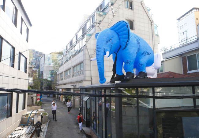 A giant elephant sculpture is installed atop a building in Pil-dong. (2016 Street Arts Festival Organizing Committee)