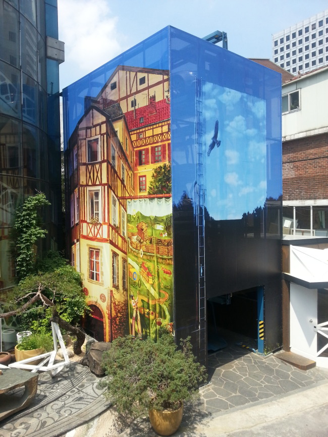 A parking tower is wrapped with a facade printed with photographs by Han Sung-pil. (2016 Street Arts Festival Organizing Committee)