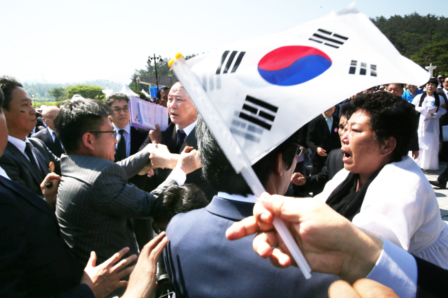 Families of those who lost their lives in the May Uprising protest against Minister of Patriots and Veterans Affairs Park Sung-choon during the commemoration ceremony in Gwangju on Wednesday. (Yonhap)