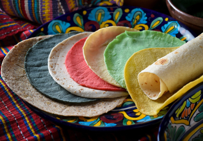 A colorful assortment of tortillas offered locally. From left, Whole Wheat flour (LaTapatia), Blue Corn (Vallaria), small flour fajita (Sol de Oro), Red Chile corn (Vallaria), white corn (Vallaria), Cactus corn (Vallaria), yellow corn (Mission), and large flour (LaTapatia). (Fresno Bee/TNS)