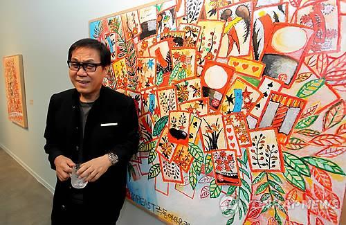 Singer and artist Cho Young-nam poses with his painting at an exhibition. (Yonhap)