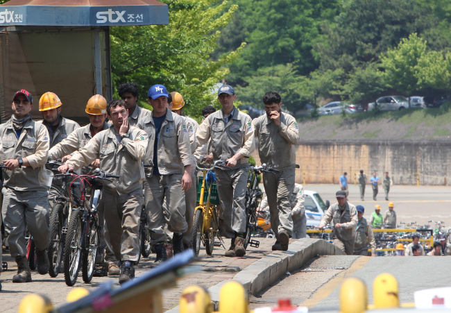 STX Offshore and Shipbuilding workers leave the grounds of the shipyard in Changwon, South Gyeongsang Province during lunch time on Wednesday. Yonhap