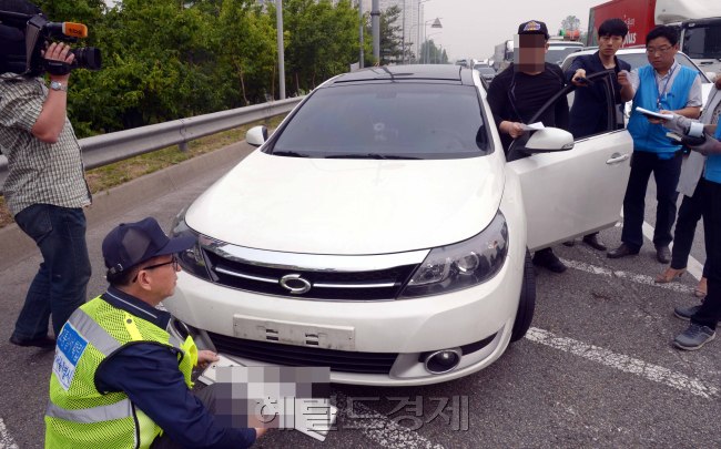 서울시ㆍ구ㆍ경찰청 합동단속반이 26일 오전 자동차세 및 과태료 등 상습체납 차량을 적발하고 번호판을 영치하고 있다. 번호판 영치는 시민의 올바른 체납금 납부의식과 안전한 교통문화 조성에 기여하기 위해 마련됐으며 420명의 인원과 장비 107대가 동원됐다. 방법은 번호판인식시스템이 장착돼 있는 카메라장착차량이 체납및 범법차량을 1㎞ 전방에서 인식하고 스마트폰으로 후방단속인력에 연락을 주면 갓길로 체납차량을 인도해 적법절차를 통한 고지및 번호판강제유치 절차에 들어가게 된다.  정희조 기자/checho@