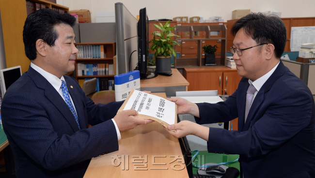 더불어민주당 박정(왼쪽) 의원이 30일 오전 서울 여의도 국회 의안과에서 20대 국회 1호 법안을 제출하고 있다./ 안훈 기자 rosedale@heraldcorp.com