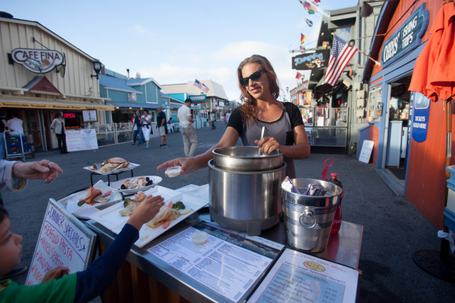 Lauren Libera passes out free samples of clam chowder at Crab Louie’s Bistro on Fisherman’s Wharf in Monterey, California, in 2014. (Patrick Tehan/Bay Area News Group/TNS)