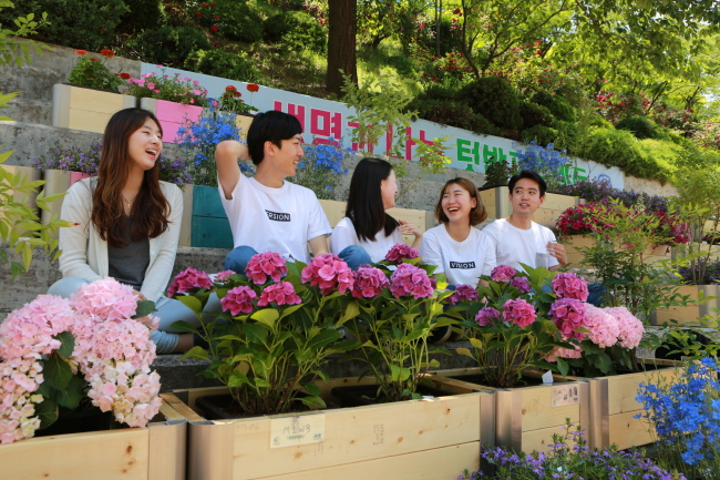 생명과 나눔 프로젝트에 참여한 학생들이 화사한 꽃물결로 새롭게 단장된 교내 콘트리트 스탠드에서 환하게 웃고 있다.
생명과 나눔 프로젝트에 참여한 학생들이 화사한 꽃물결로 새롭게 단장된 교내 콘트리트 스탠드에서 환하게 웃고 있다.