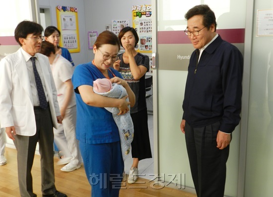 이낙연 전남지사(오른쪽)가 김연주 수간호사가 안고 온 신생아를 지긋이 바라보고 있다. 사진 왼쪽은 정기현 병원장. 박대성기자 / parkds@heraldcorp.com
