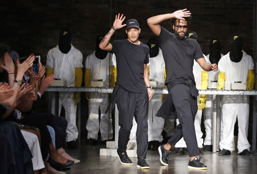 Fashion design duo, Dao-Yi Chow (left) and Maxwell Osborne make an appearance on the runway at the conclusion of their Public School fashion show in New York on Tuesday. (AP-Yonhap)