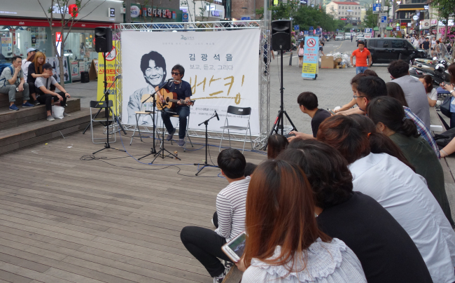 A busker performs on Sunday evening on an outdoor stage in Sinchon set up by the Seodaemun-gu Office for musicians paying tribute to the late singer Kim Kwang-seok. (Rumy Doo/The Korea Herald)