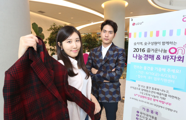 LG유플러스 홍보 모델들이 종합 미디어 플랫폼인 ‘LTE비디오포털’ 광고모델로 활약한 배우 유아인씨가 광고 촬영 당시 입었던 의상을 들어 보이고 있는 모습.