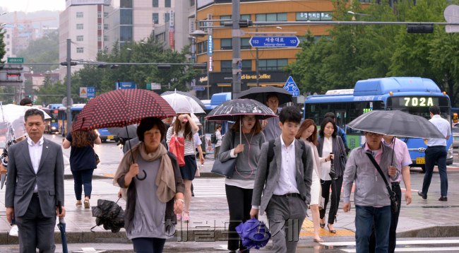 장마전선의 영향으로 전국적으로 비가 오는 가운데 15일 서울 광화문에서 출근하는 이들은 비옷과 우산으로 무장했다. 기상청은 19일부터 제주 남부지방에 전선이 상륙하고 중부지방은 21일부터 장마가 시작된다고 예보했다.   정희조 기자/checho@heraldcorp.com