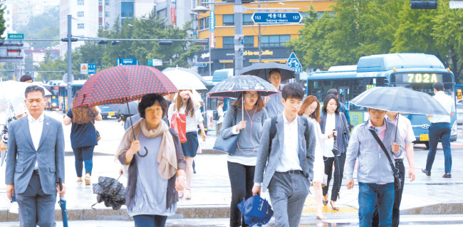 장마전선의 영향으로 전국적으로 비가 오는 가운데 15일 서울 광화문에서 출근하는 이들은 비옷과 우산으로 무장했다. 기상청은 19일부터 제주 남부지방에 전
선이 상륙하고 중부지방은 21일부터 장마가 시작된다고 예보했다. 정희조 기자/checho@heraldcorp.com