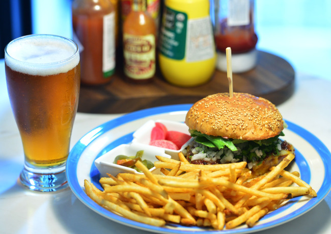 The chicken burger is crafted with pan-seared chicken, a blend of monterey jack and cheddar cheese, bacon jam, scallions and pickled beet mayo and swaddled in a housemade bun. (Yoon Byung-chan/The Korea Herald)