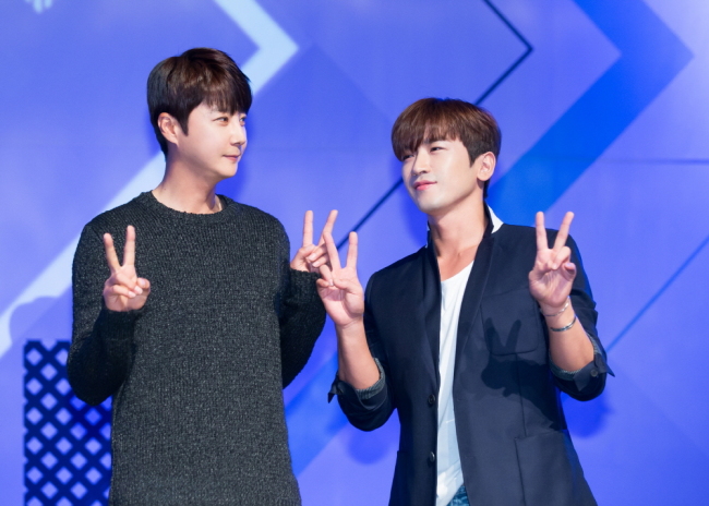 Shin Hye-sung (left) and Lee Min-woo, members of boy group Shinhwa, pose at a press conference for the new audition program “Boys 24” in Seoul Thursday. The two will be acting as mentors to the contestants. (CJ E&M)