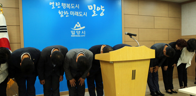 Miryang mayor Park Il-ho, a member of the Saenuri Party, along with members of the city‘s council bow in a show of apology to the residents over the scrapped new airport plan on Tuesday. (Yonhap)
