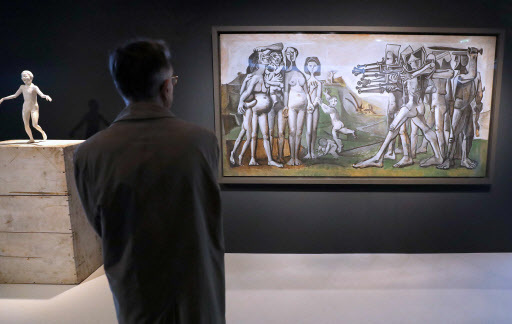 A man looks at the painting “Massacre in Korea” by Spanish painter Pablo Picasso during the exhibition “Jacques Chirac, or the Dialogue Between Cultures and Civilizations” at the Quai Branly Museum in Paris on Monday. (AFP-Yonhap)