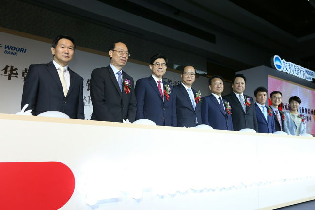 24일 중국 북경 웨스틴호텔에서 열린 ‘우리은행-KEB하나은행 공동 원화청산은행 출범식’에서 이광구 우리은행장(사진 왼쪽에서 3번째)이 유일호 부총리 겸 기획재정부 장관(사진왼쪽에서 5번째), 김민호 한국은행 부총재보(사진 왼쪽에서 4번째) 및 현지은행 관계자들과 함께 기념촬영을 하고 있다.
[사진제공=우리은행]
