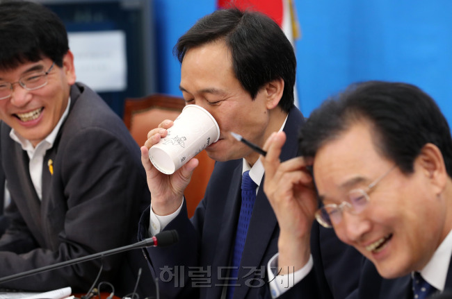 우상호 더불어민주당 원내대표(가운데)가 30일 오전 서울 여의도 국회에서 열린 정책조정회의에서 웃으며 물을 마시고 있다. 우 원내대표는 이날 회의에서 정부의 맞춤형 보육 강행을 언급하며 “국민경고, 야당경고 무시하고 진행한 정책의 후과가 어떻게 나타나는지 반드시 본때를 보이겠다. 맘대로 하십시오”라고 비판했다.박해묵 기자/mook@heraldcorp.com