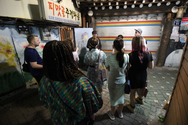 International travelers and expats participate in Korea’s only “Ghost Tour,” which takes them on a guided walk through locations known to have a dark or superstitious history. (Julie Jackson / The Korea Herald)