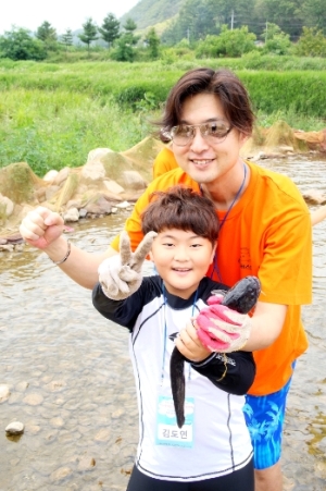 농촌체험마을 ‘수미마을’에서 엄마와 함께 메기잡기 놀이를 즐기는 어린이. [사진=농정원]