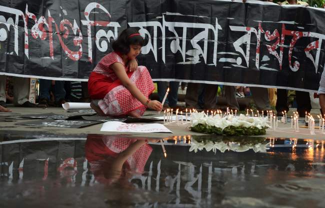 Indian social activists light candles during a protest in Kolkata on July 2, 2016, against a fatal attack on a restaurant in the Bangladeshi capital Dhaka. Heavily armed militants murdered 20 hostages in Bangladesh, hacking many of their victims to death, before six of the attackers were gunned down at the end of a siege July 2 at a restaurant packed with foreigners. As the Islamic State (IS) group claimed responsibility for the carnage at the start of the Eid holiday, Prime Minister Sheikh Hasina said she was determined to eradicate militancy in the mainly Muslim nation. / AFP PHOTO