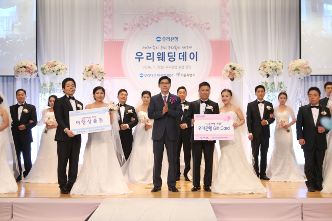 3일 서울 중구 소공로 소재 우리은행 본점에서 열린 ‘우리다문화장학재단, 제5회 우리웨딩데이’에서 이광구 우리은행장(우리다문화장학재단 이사장)(사진 가운데)의 주례로 7개국의 다문화가족 10쌍을 대상으로 결혼식을 실시한 뒤 다함께 기념촬영을 하고 있다.
[사진=우리은행 제공]
