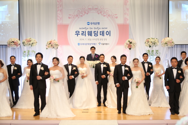 3일 서울 중구 소공로 소재 우리은행 본점에서 열린 ‘우리다문화장학재단, 제5회 우리웨딩데이’에서 이광구 우리은행장(우리다문화장학재단 이사장)(사진 가운데)의 주례로 7개국의 다문화가족 10쌍을 대상으로 결혼식을 실시한 뒤 다함께 기념촬영을 하고 있다.
[사진=우리은행 제공]