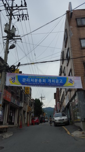 성남시 중원구 금광1구역의 골목에 관리처분총회 개최를 축하하는 현수막이 걸려있다.
