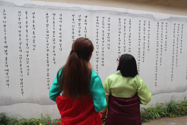 K-Travel Bus participants dressed in hanbok explore Daegu’s “Modern Streets” tourist attractions. (Julie Jackson/The Korea Herald)