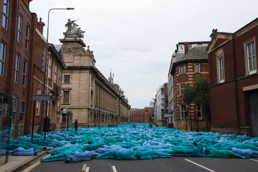Naked volunteers, painted in blue to reflect the colors found in Marine paintings in Hull’s Ferens Art Gallery, participate in U.S. artist Spencer Tunick’s “Sea of Hull” installation in Hull, England, Saturday. (AFP-Yonhap)
