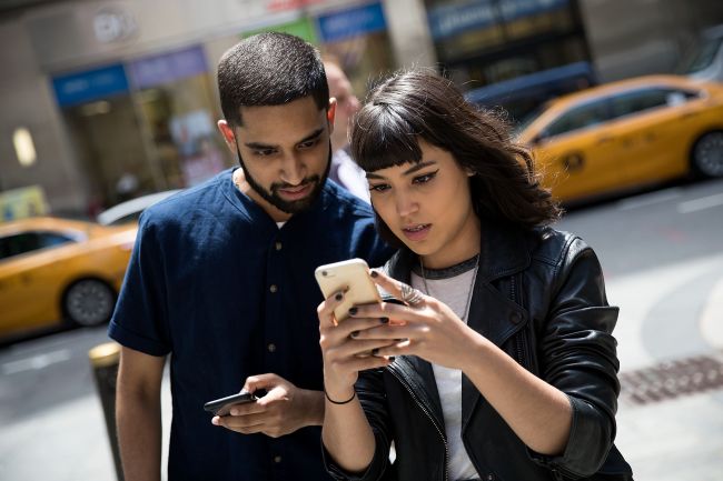 Sameer Uddin (left) and Michelle Macias play Pokemon Go on their smartphones outside of Nintendo’s flagship store in New York on Monday. (Yonhap-AFP)