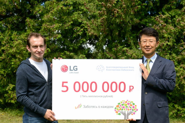 LG전자 CIS지역 기획관리담당 한재동 상무(오른쪽)가 러시아 유명 배우이자 하벤스키 재단을 운영하고 있는 콘스탄틴 하벤스키에게 후원금을 전달했다.