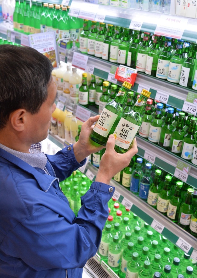 A customer buys Lotte Chilsung's soju brand Cheoumcheoreom at a local grocery store./ The Investor (Lee Sang-sub)