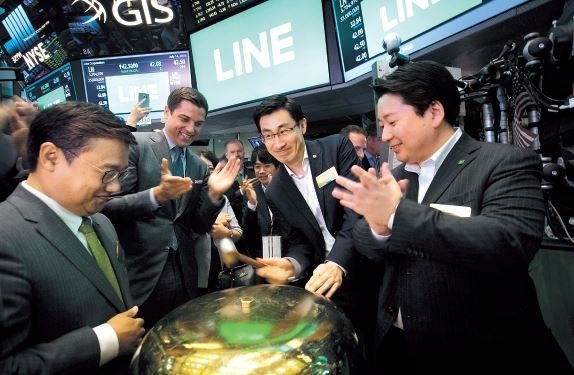 Line Corp. CFO Hwang In-joon (left), CSO Jun Masuda (right) and CGO Shin Jung-ho (center right) ring the opening bell as executives and guests of the company visit the New York Stock Exchange to celebrate their IPO in New York on Thursday. (EPA-Yonhap)
