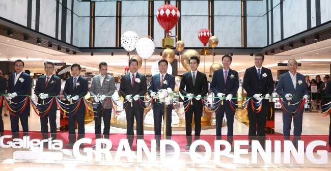 Hanwha Galleria president Hwang Yong-deuk (sixth from left) and actor Song Seung-hun (seventh from the left) attend the opening ceremony for its duty-free shop in Yeouido's 63 Building on Friday.