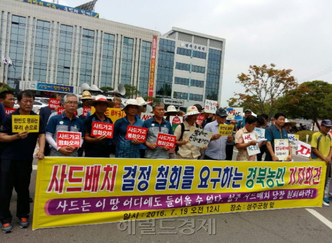 전국농민회총연맹 경북도연맹 회원들이 19일 정오 경북 성주군청 앞에서 사드 성주배치 결정 철회를 촉구하는 기자회견을 열고 있다.[사진=김병진기자]